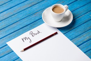 pencil and paper with inscription r cup of coffee on blue wooden table